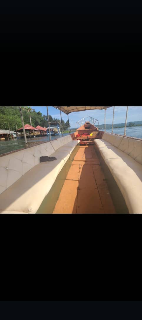 View from inside the boat toward the bow, river and lush banks ahead