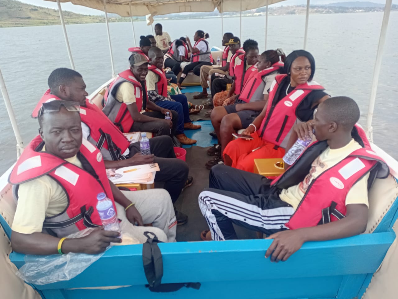 Large group of passengers aboard the Nile cruise boat, red life vests, wide open water