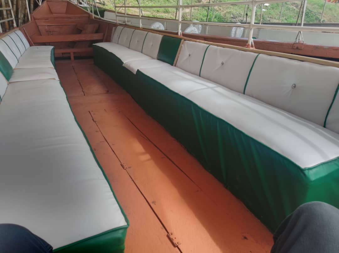 Inside the boat — green-trimmed white bench seating along the sides