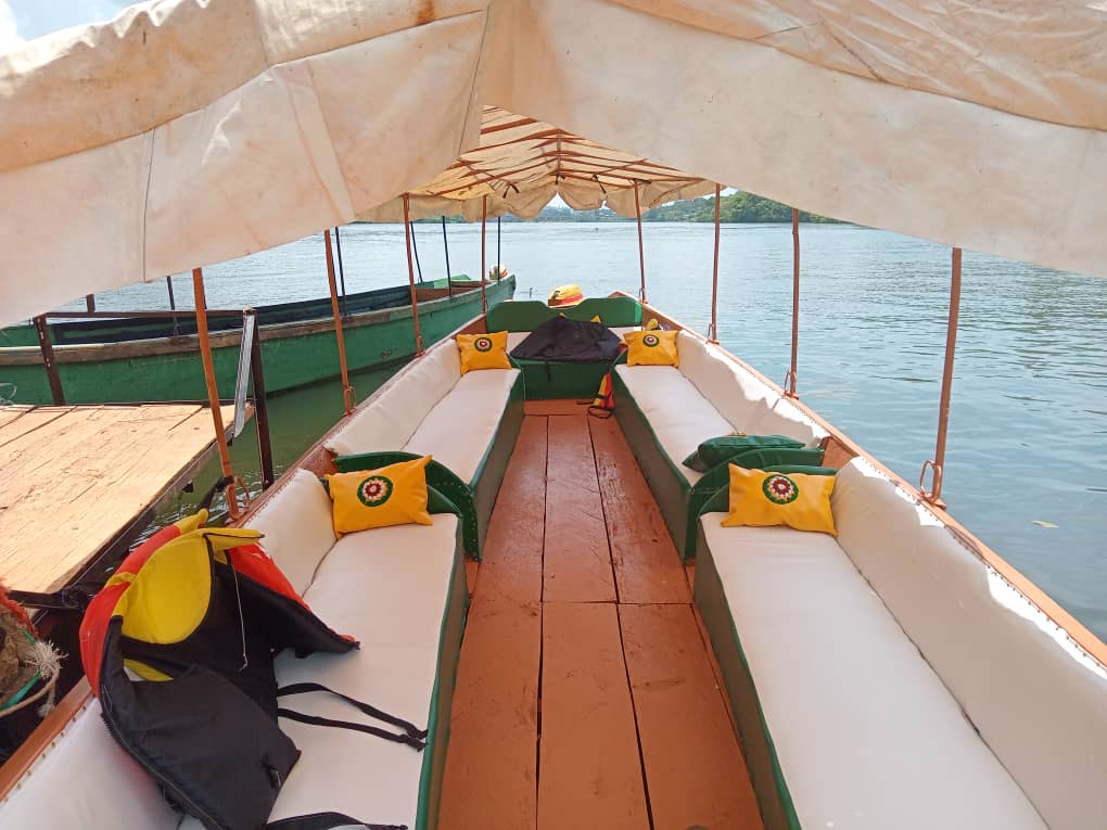 Boat interior with cushioned bench seating and yellow embroidered pillows, Nile ahead