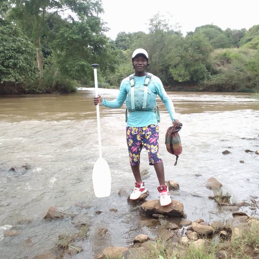 James, river guide, standing at the edge of the Nile with his paddle