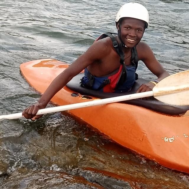 Techi, junior river guide, smiling from his kayak on the Nile