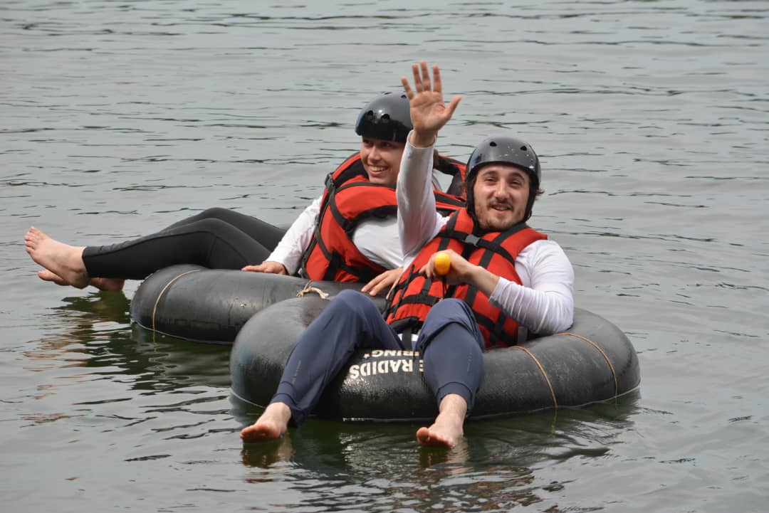 Tourists waving and smiling from their tubes on the Nile